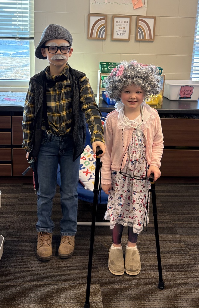 Two children dressed as elderly adults with canes and costumes.