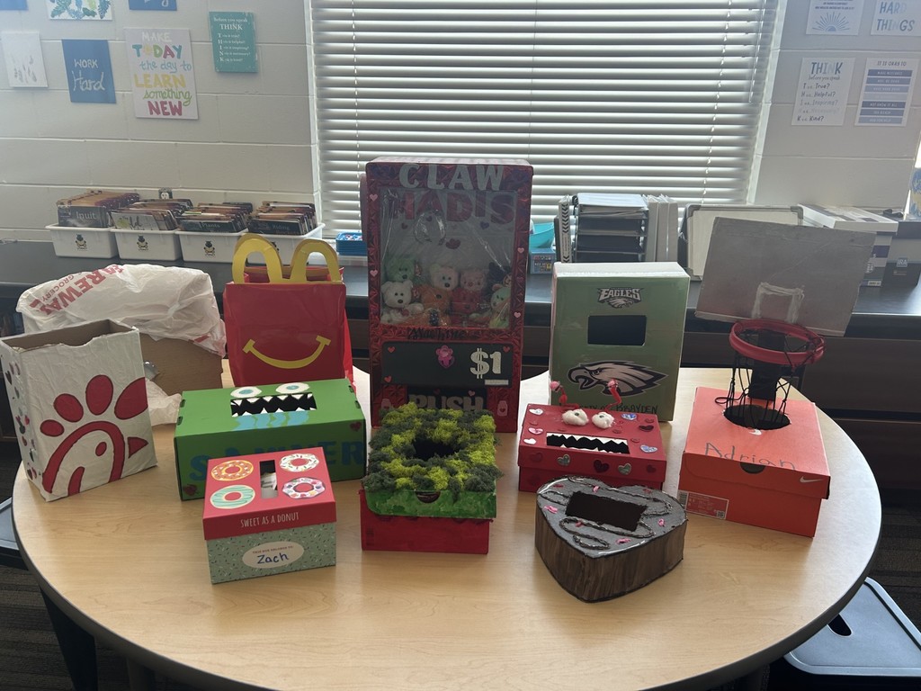 A table displays creative student-made arcade boxes, including a claw machine, monster-themed game, donut box, and heart-shaped design.