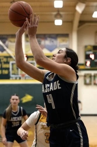 Cascade girls basketball player wearing number 4 attempts a layup as opposing players defend in a gymnasium.