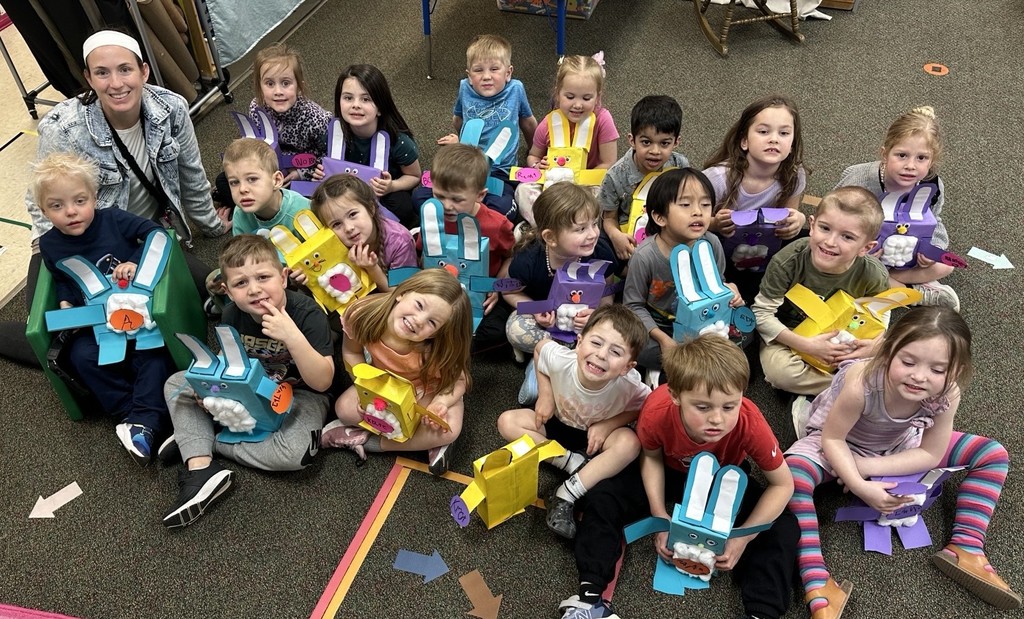 A group of students sitting on the floor smiling.