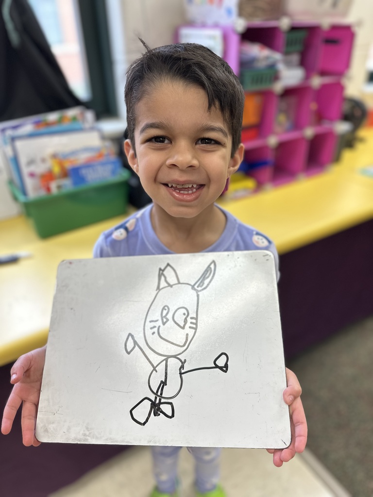 A child holding a drawing of a bunny.