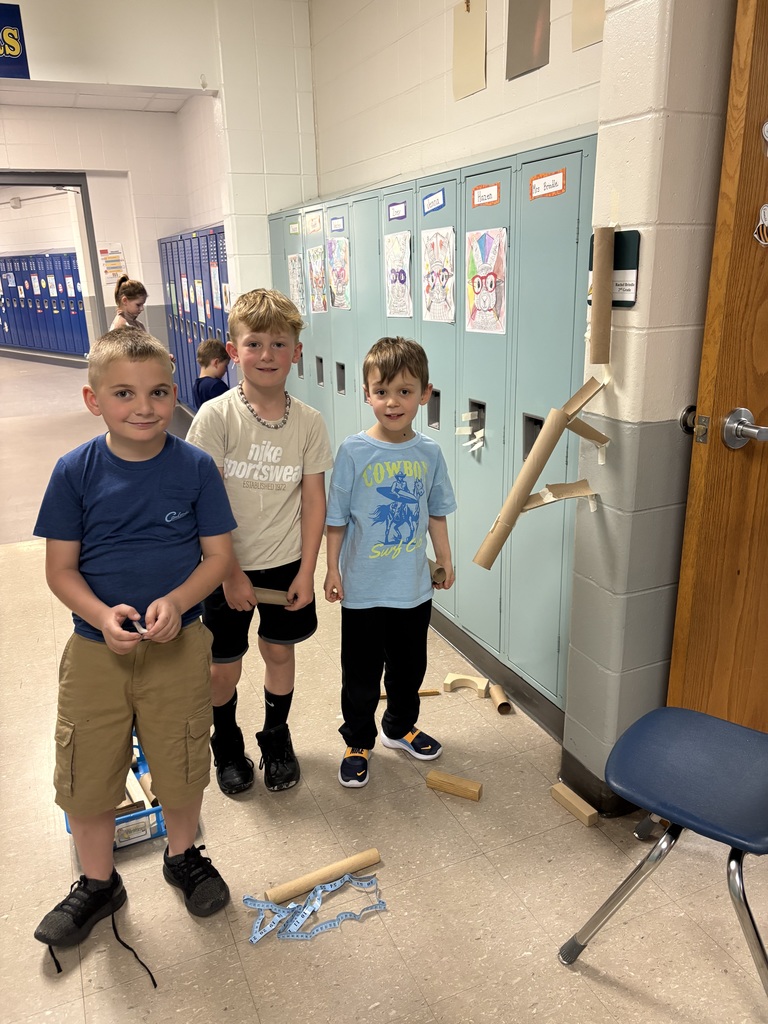 Three boys making marble ramps in the hallway.