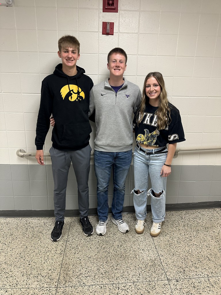 Three students smiling at the camera.