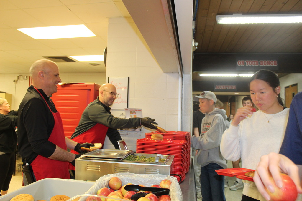 Mr. Kedley & Mr. Wernimont serving up lunches to give the kitchen staff a break on "School Lunch Hero Day"!