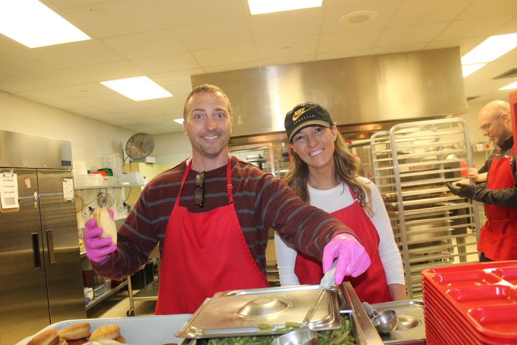 Mr. Hatcher & Mrs. Goldsmith  serving up lunches to give the kitchen staff a break on "School Lunch Hero Day"!