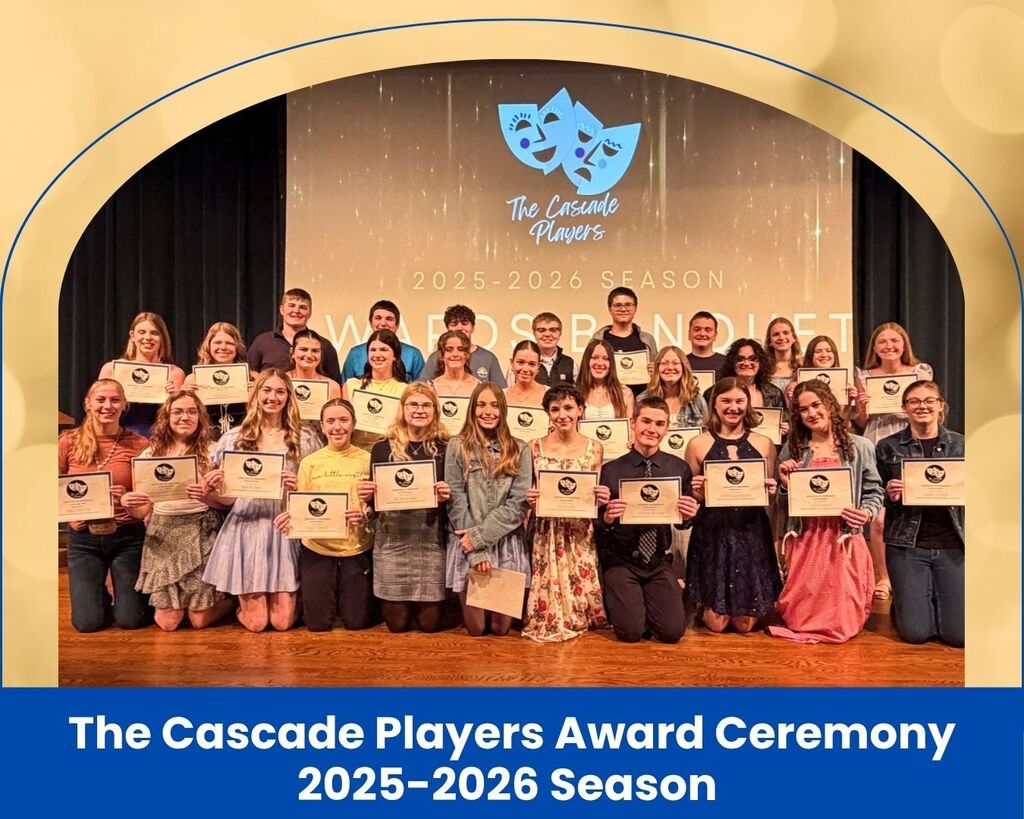Group of students on stage holding up certificates.