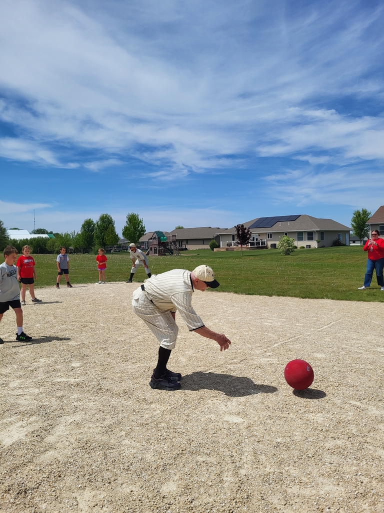 Man bending down to get a red ball.
