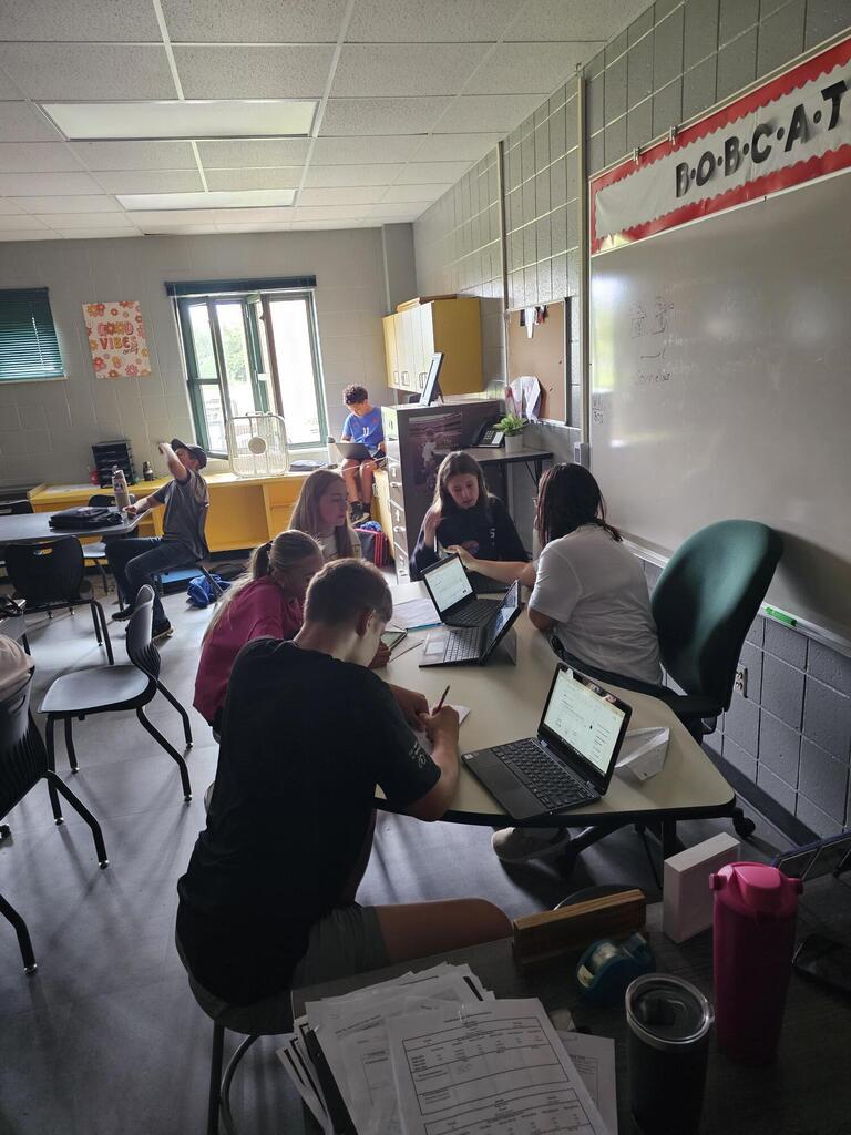 Students sitting around a desk.