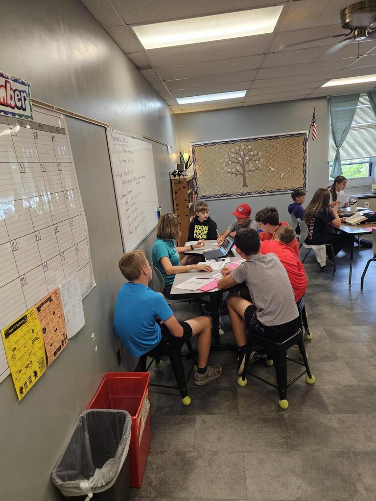 Students sitting around a desk.