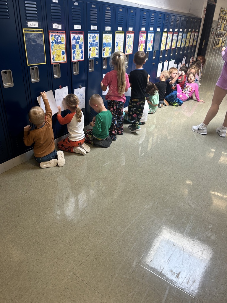 Students drawing on paper that is attached to a locker.