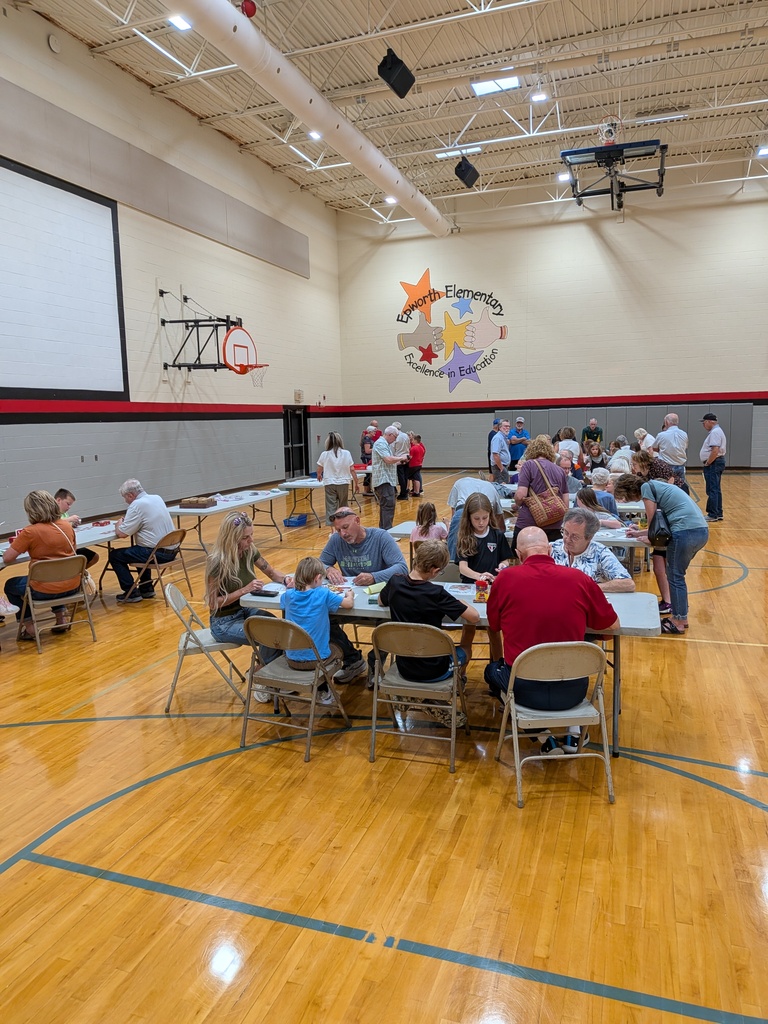 Students, families, and older adults participate in activities at tables inside the Epworth Elementary gymnasium.