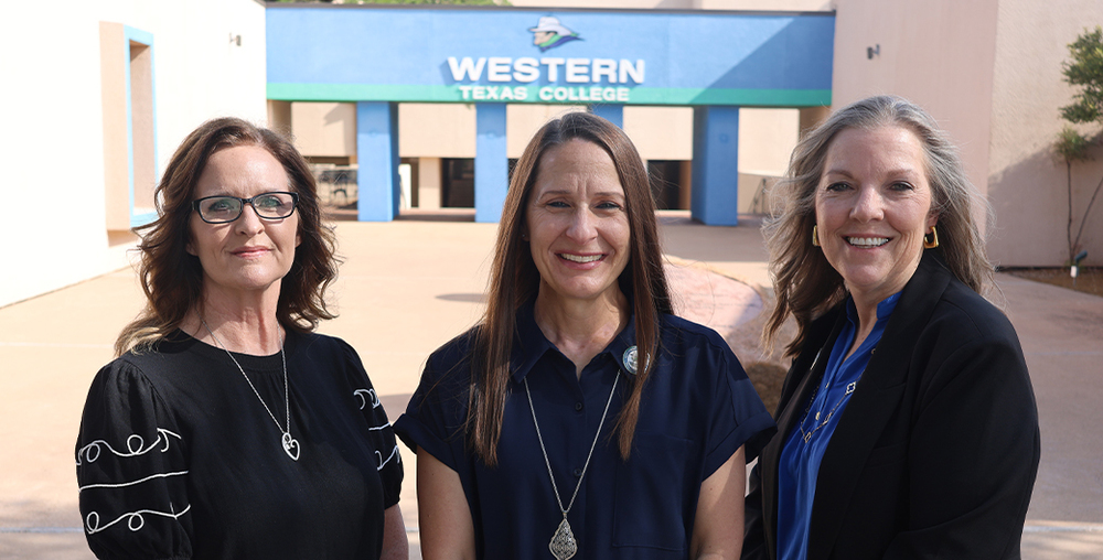 Tevian Sides, Dr. Laurie Sharp, and Laura Caswell stand on the main walkway in front of the WTC Arch.