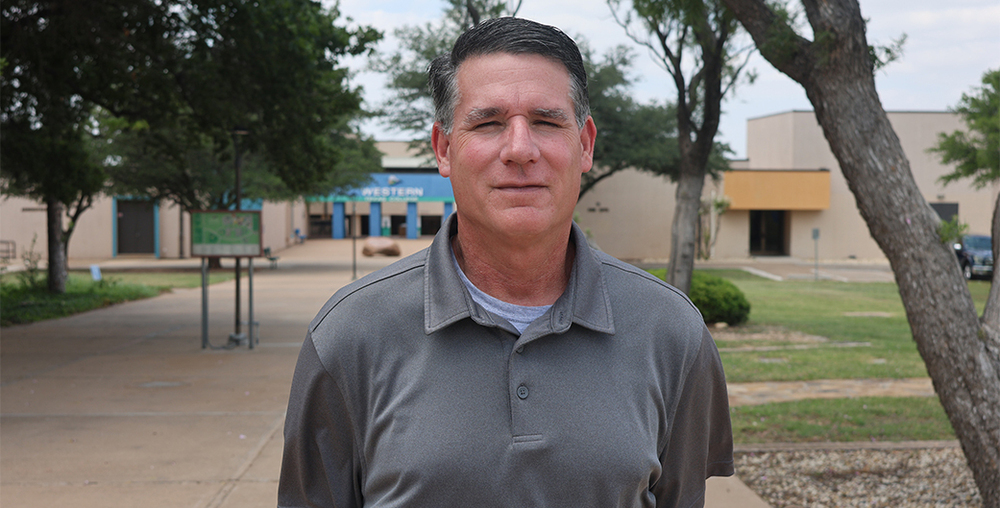 Shawn Fonville, Vice President for Career and Technical Education and Continuing Education, stands on the front of the Western Texas College campus.