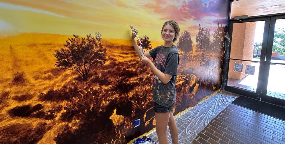 Lexi Antonick works on the new mural in the Western Texas College Resource Center.