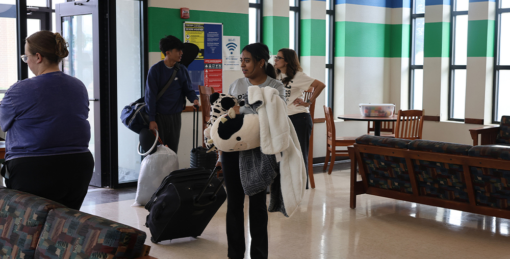Student holding personal items for summer bridge move in day