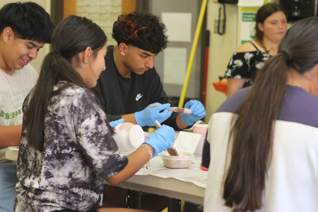 Students focus on glazing the pottery pieces they created.