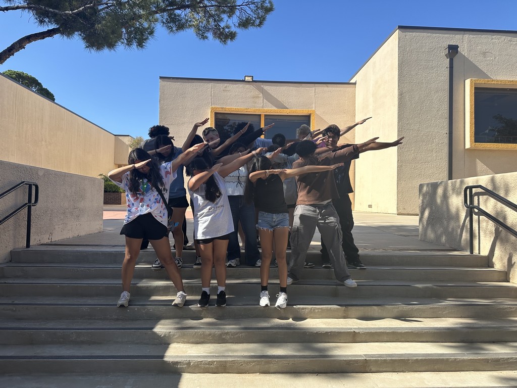 Upward Bound students perform a dance move on the steps of the courtyard.