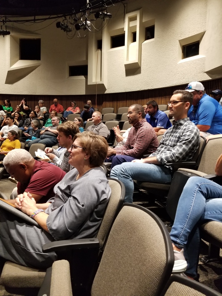 Employees smile while listening to the speaker during opening session.