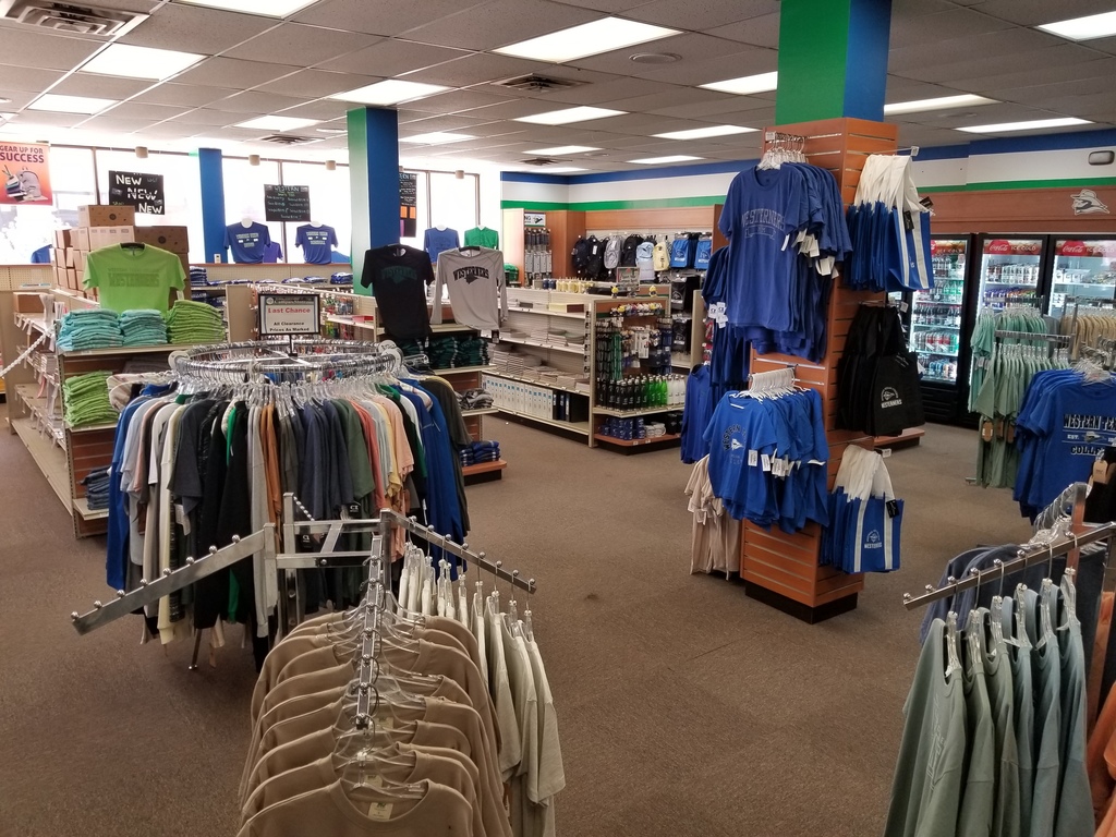 A view of the bookstore that shows racks of t-shorts, school supplies, and drink coolers.