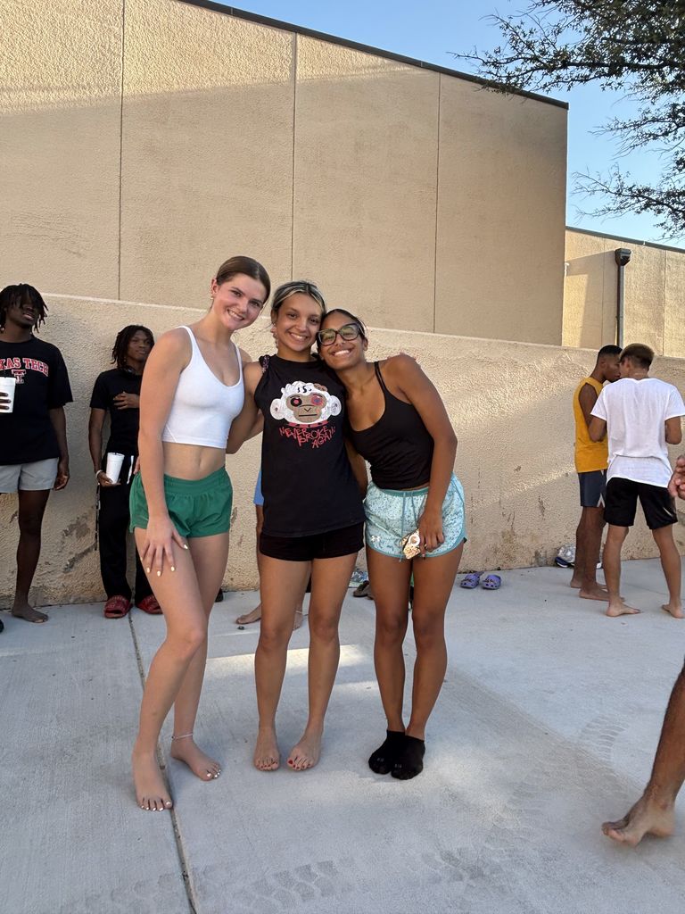 Three students smile for the camera.