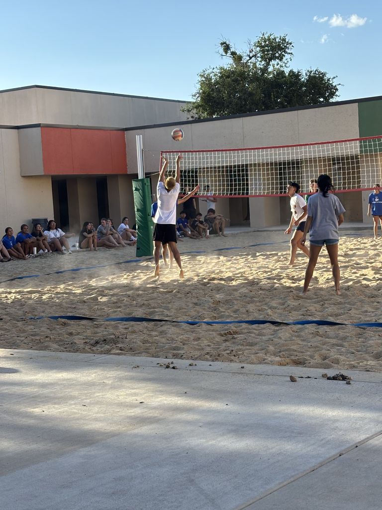 A player tries to spike the ball as it comes over the net.