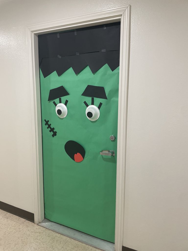 A dorm door covered in green and black paper to look like Frankenstein's face.