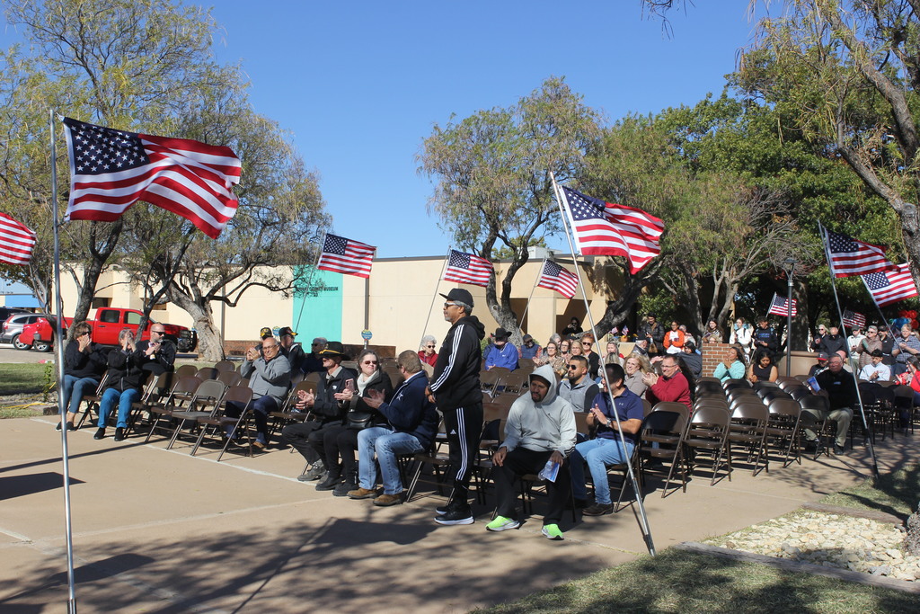 Another veteran stands to be recognized while the audience claps in appreciation.