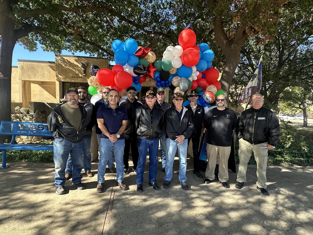 Veterans pose in front of colorful balloons outside the Scurry County Museum at Western Texas College.