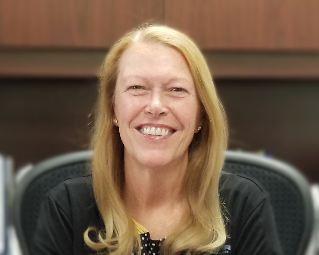 Dr. Beebe poses for a photo at her desk.