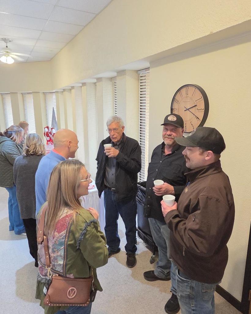 Employees enjoy coffee and punch while chatting.