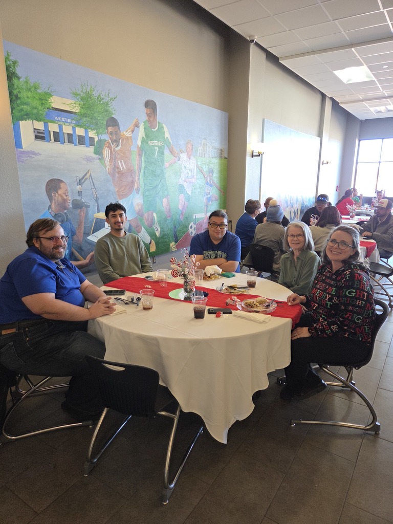 Technology Department employees Faculty and staff seated at a round table with holiday decorations.