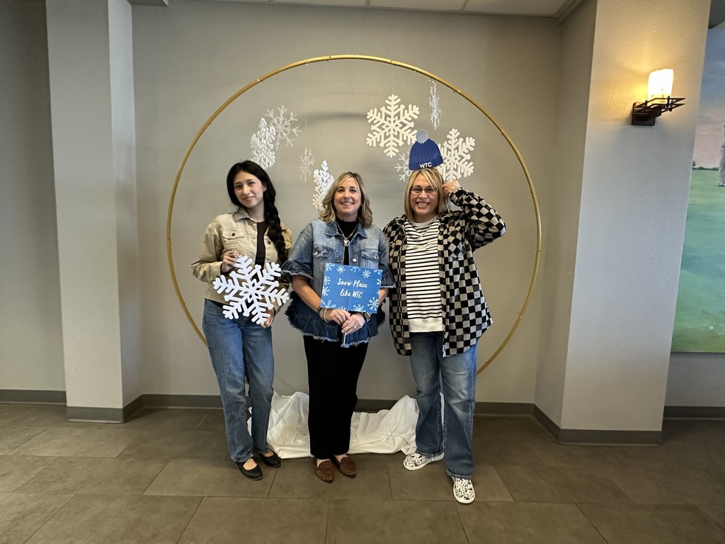 Brittany, Michelle, and Tabitha pose with snowflake props in the cafeteria.