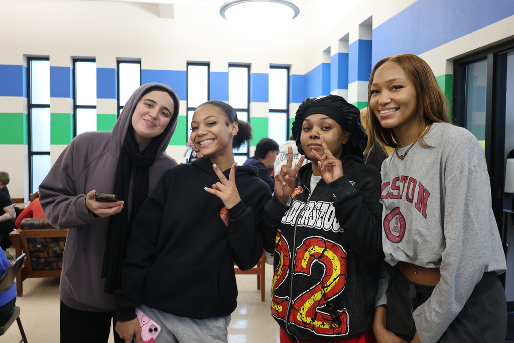 A Group of students smiling and showing deuces with their hands.