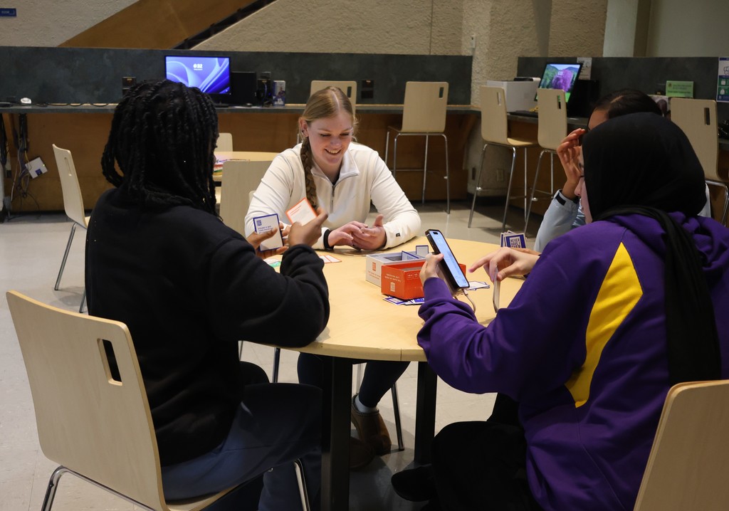Students gather around a table playing card games during WTC Student Center Game Night.