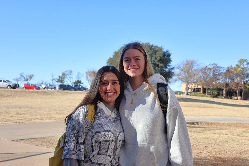 Two Western Texas College students smiling together outdoors on campus during the first day of classes.