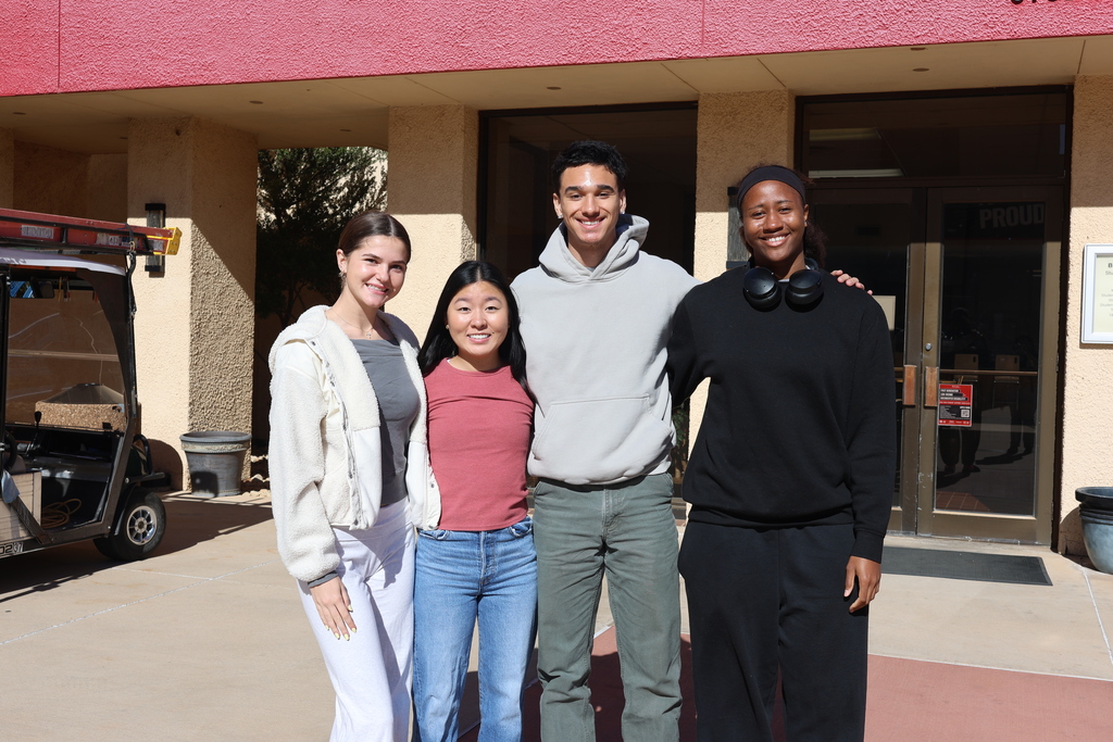 Four Western Texas College students posing together outside a campus building on the first day of classes.