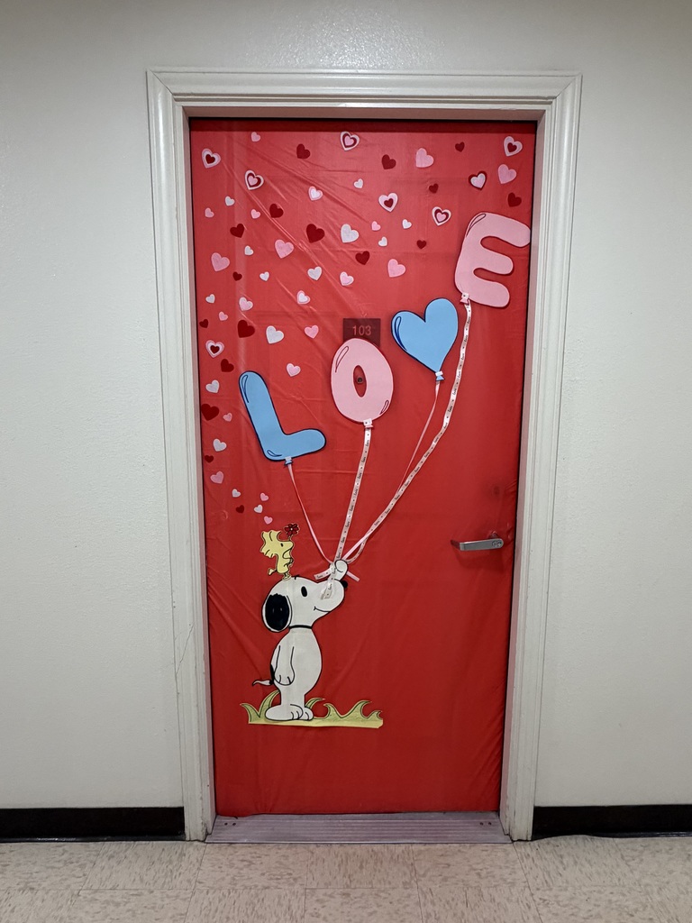 Red door decorated with Snoopy holding LOVE balloons and floating hearts for Valentine’s Day.