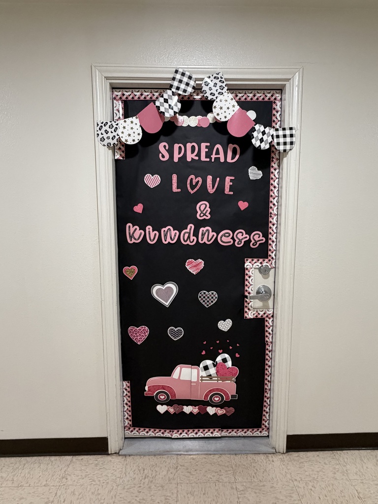 Black door display reading “Spread Love & Kindness” with hearts and a pink pickup truck.