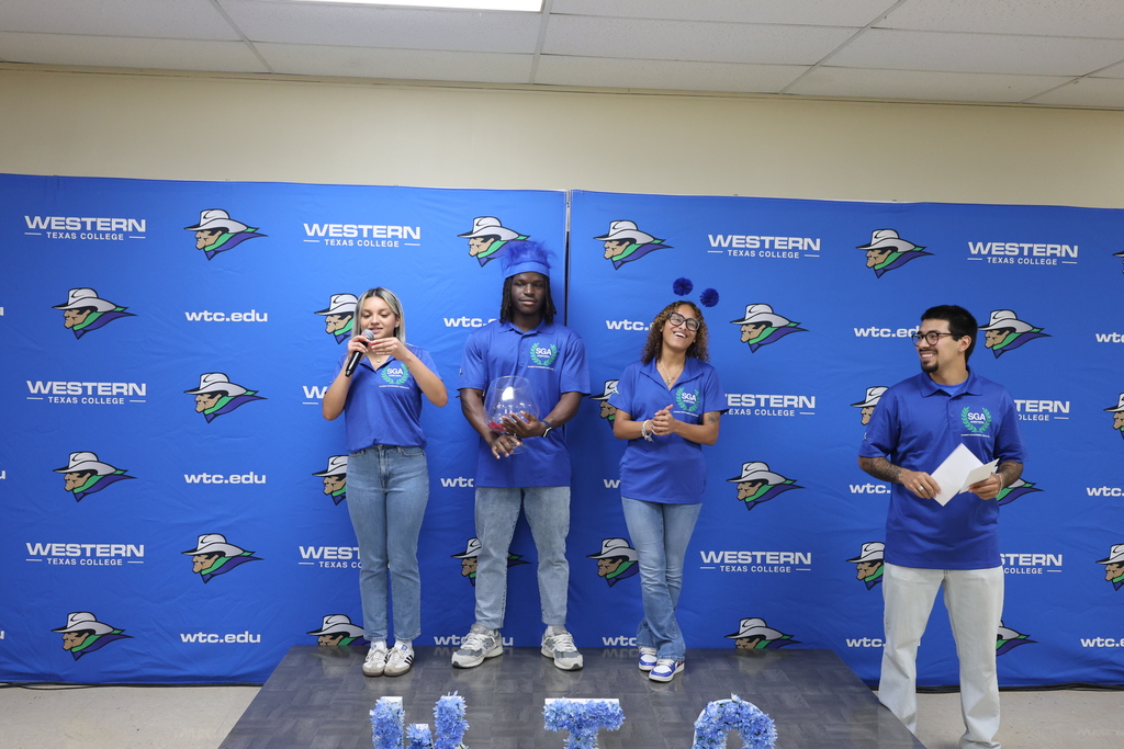 Student Government Association members draw raffle prize on stage in front of WTC backdrop.