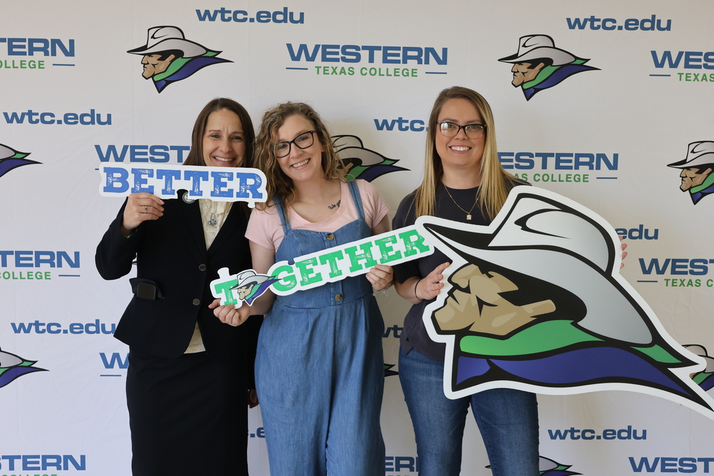 Three women hold Better Together signs and mascot cutout in front of Western Texas College backdrop.