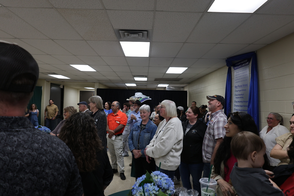 Community members listen and smile during Western Texas College gathering.