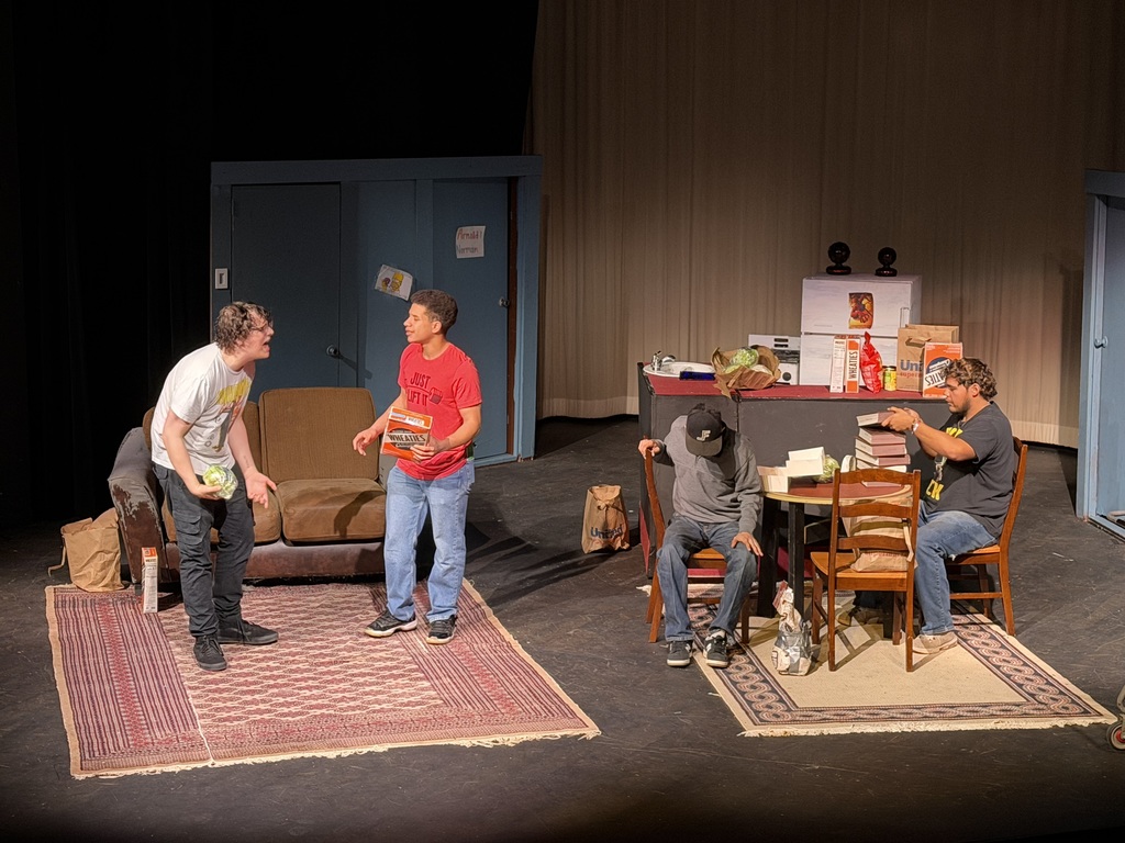 Four actors perform scene in apartment set during Western Texas College production of The Boys Next Door.