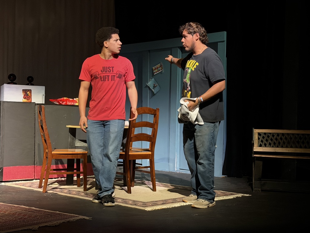 Two actors argue near kitchen table on apartment set during Western Texas College production of The Boys Next Door.