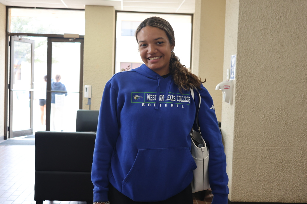 A woman wearing a WTC softball hoodie smiles for the camera.