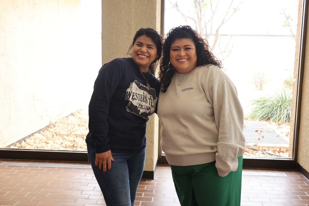 Two women wearing WTC gear smile with their heads touching.
