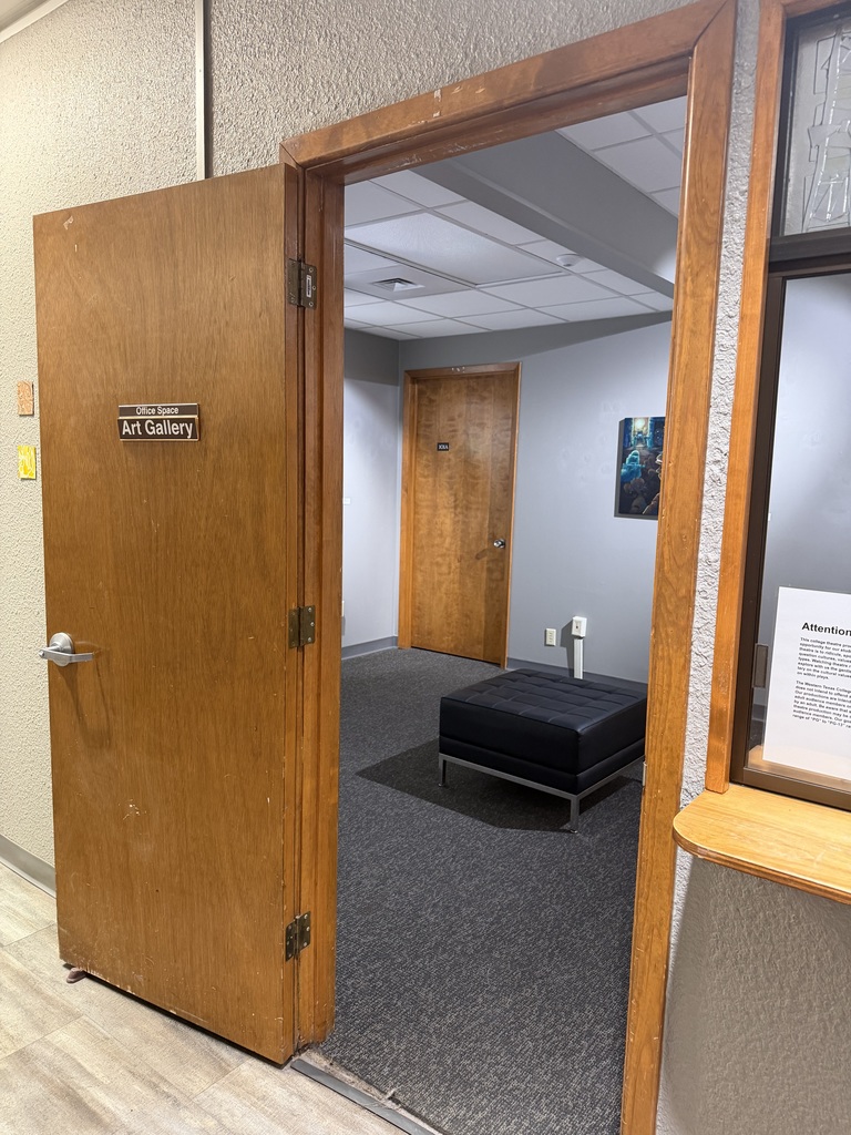 An office door stands open with a gallery space beyond.