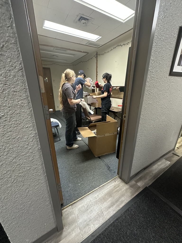 Students sort costumes and props in backstage dressing room during theater prep