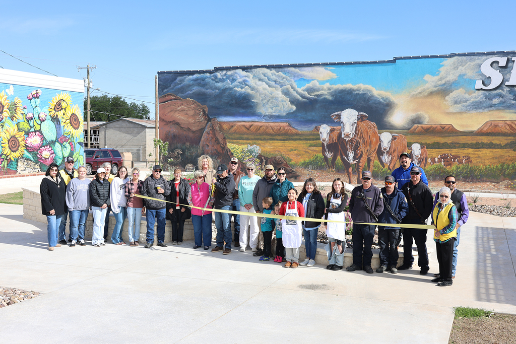 Community members gather for ribbon cutting in front of Snyder mural downtown.