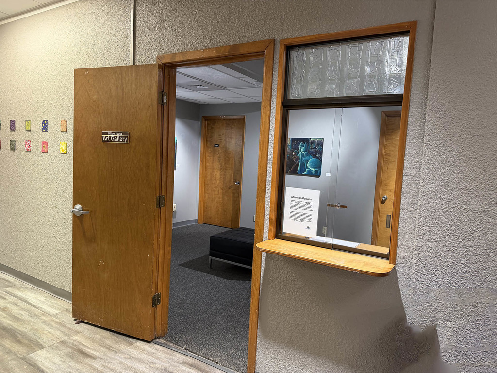 Open doorway to campus art gallery with display window and artwork inside.