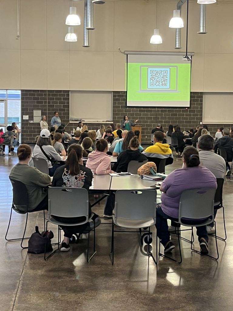 Audience listens to speaker during student event in large campus hall.